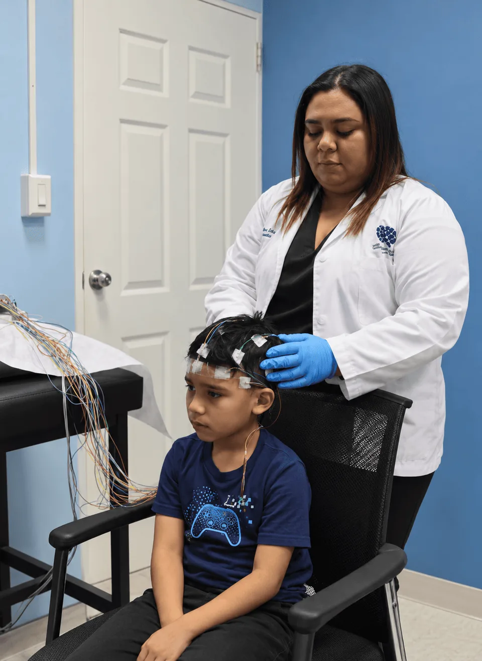 Profesional de salud colocando electrodos para un electroencefalograma a un niño